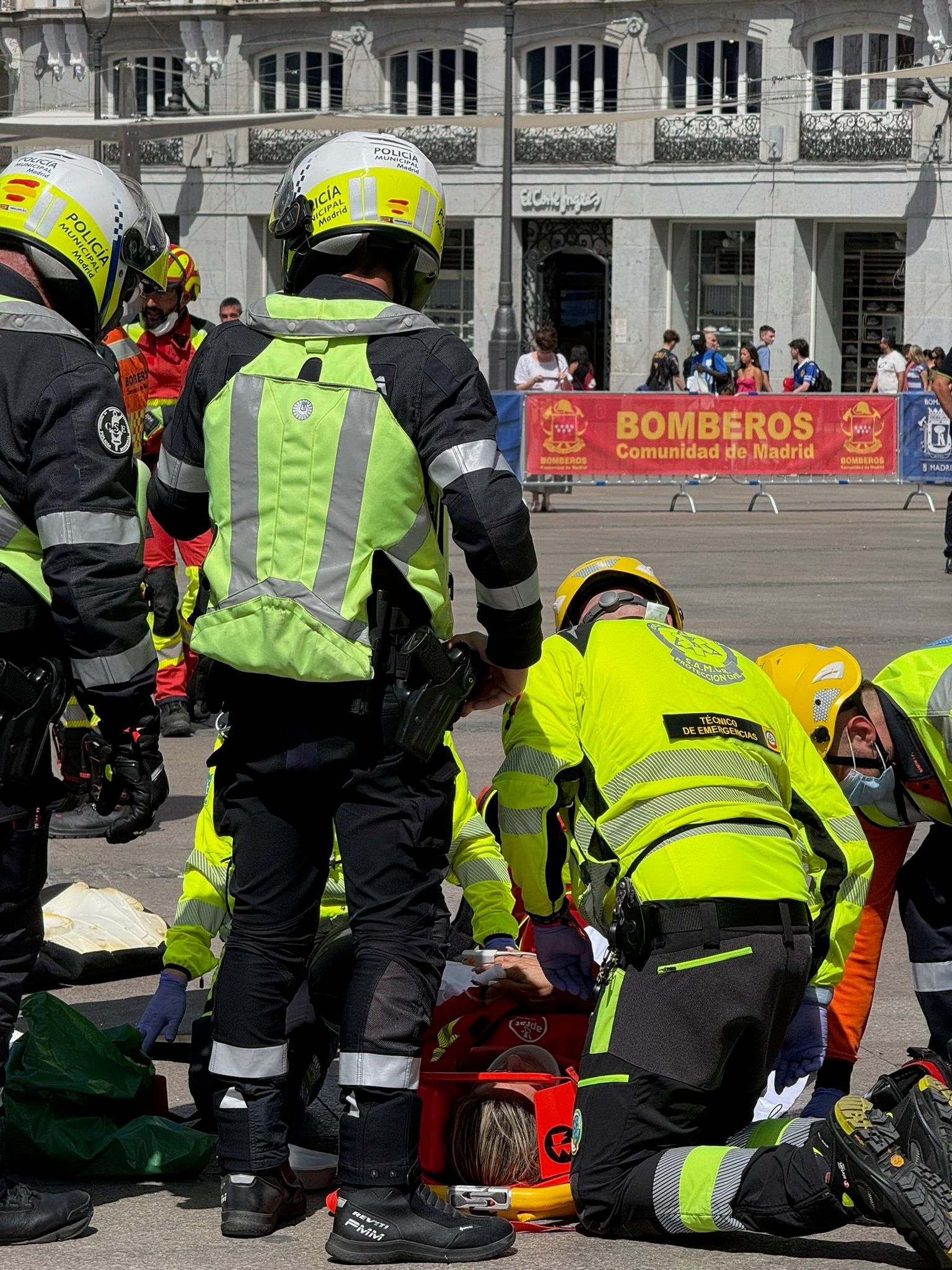 Equipos de SAMUR-Protección Civil y bomberos atendiendo a una persona en una calle de Madrid